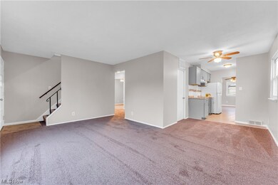 Unfurnished living room featuring ceiling fan and light colored carpet