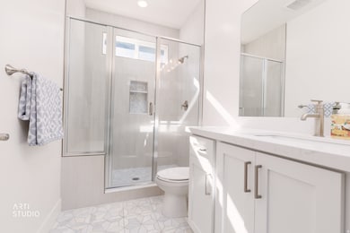 Bathroom with vanity, a shower stall, and light tile patterned floors