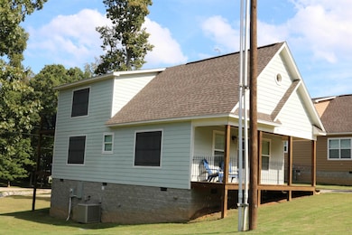 Back of house with cooling unit and a yard