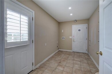Doorway to outside featuring tile patterned flooring and recessed lighting