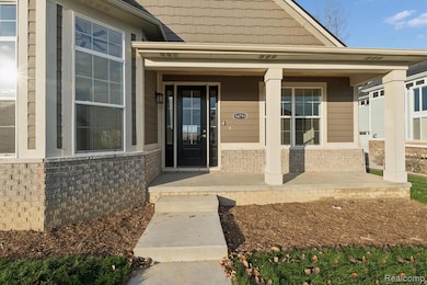 View of exterior entry featuring brick siding and covered porch