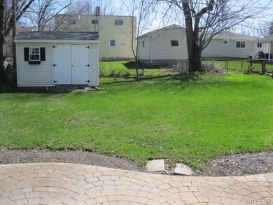 Fully fenced deep back yard has a storage shed.