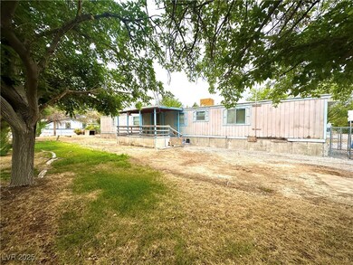 Rear view of property featuring a lawn and fence