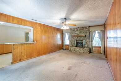 Unfurnished living room featuring wood walls, ceil