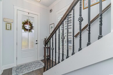 Entrance foyer with crown molding and hardwood / w