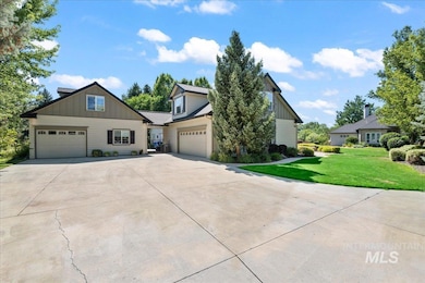 View of front of house featuring board and batten siding, driveway, an attached garage, and a front lawn