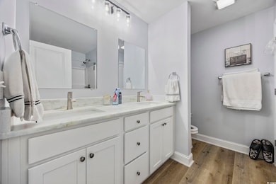 Full bath with double vanity, wood finished floors