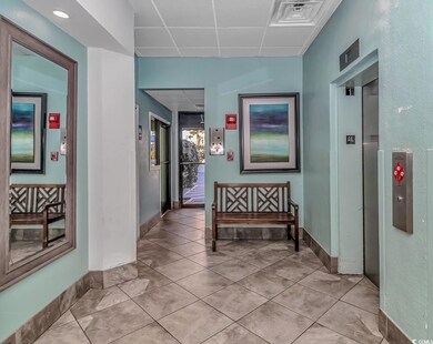 Hallway with a drop ceiling and light tile pattern