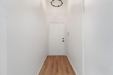 Doorway to outside featuring baseboards, an inviti