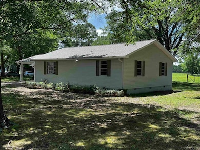 View of property exterior featuring crawl space, a yard, and a shingled roof