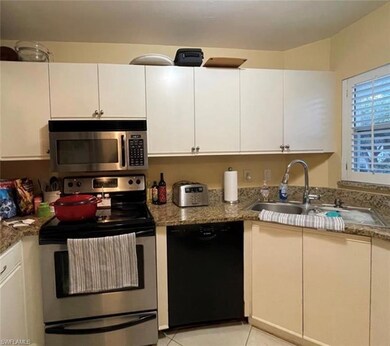 Kitchen featuring sink, white cabinets, and stainl