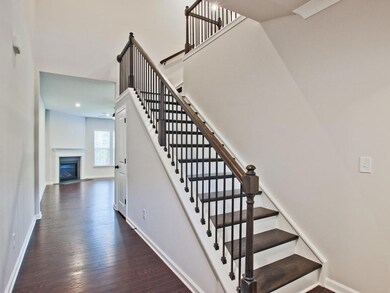 Staircase featuring wood finished floors, ceiling fan, a fireplace with flush hearth, and recessed lighting