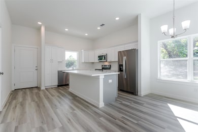 Kitchen featuring white cabinetry, stainless steel