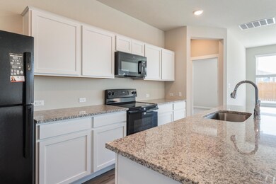 Kitchen featuring visible vents, white cabinets, 