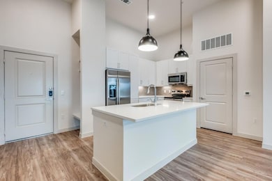 Kitchen featuring white cabinetry, sink, stainless