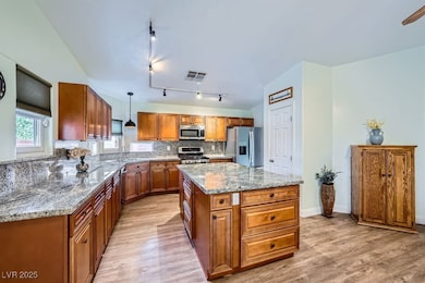 Kitchen with a sink, brown cabinetry, stainless st