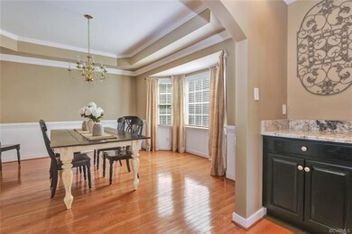 Gorgeous dining room - tray ceiling, bay window, crown molding, wainscoting, chair rail.