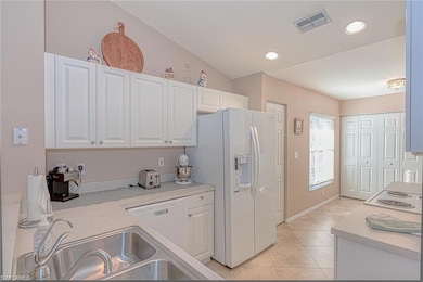Kitchen with sink, white cabinets, white appliance