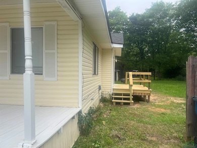 View of side of property with a wooden deck and a yard