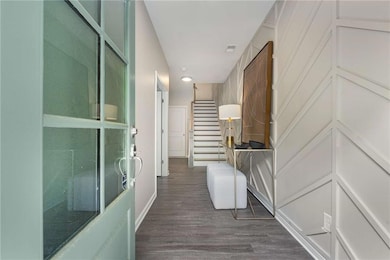 Corridor with dark wood-style floors and recessed lighting