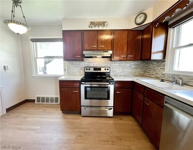 Kitchen with stainless steel finishes and tasteful backsplash