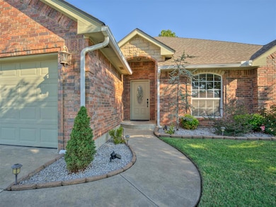 Property entrance with brick siding, an attached garage, a shingled roof, and a lawn