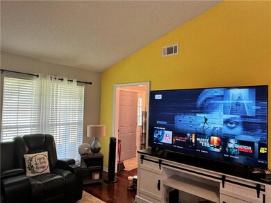 Living area featuring vaulted ceiling and dark wood-type flooring