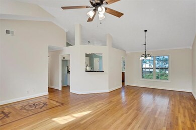 Unfurnished living room with a chandelier, a ceiling fan, baseboards, light wood-type flooring, and lofted ceiling