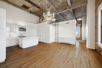 The space features high ceilings with exposed cement, brick walls and a bright, porcelain windowsills, open layout, creating a contemporary and inviting atmosphere