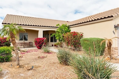 Rear view of house featuring stucco siding, a tile