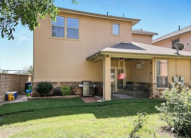 Back of property with stone siding, a patio area,
