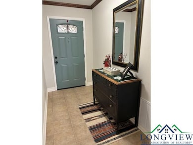 Entrance foyer featuring light tile patterned floors and crown molding