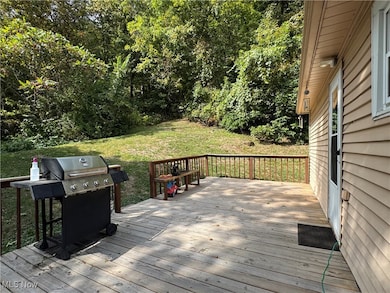 Wooden deck featuring grilling area and a lawn