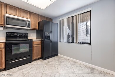 Kitchen featuring light countertops, brown cabinet