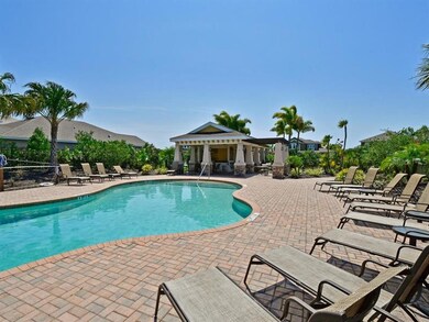 Community pool and patio lounge area with BBQ unde