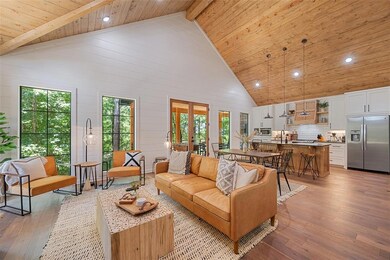 Living area with plenty of natural light, a wood ceiling with exposed beams, light wood-style flooring, high vaulted ceiling, and recessed lighting