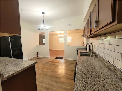 Kitchen featuring black fridge with ice dispenser,