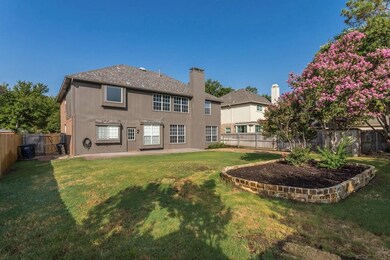 Back of property with a fenced backyard, a chimney, and a patio area