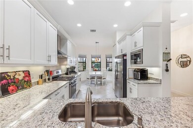 Kitchen features stainless steel appliances, vented hood.