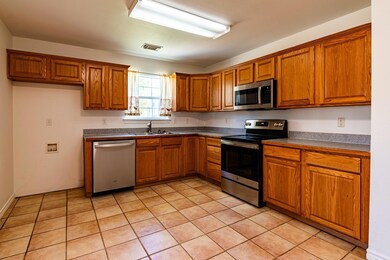 Kitchen with light tile patterned floors, applianc