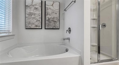 Full bath featuring a shower stall and a garden tub