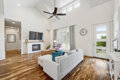 Living room with high vaulted ceiling, a glass co