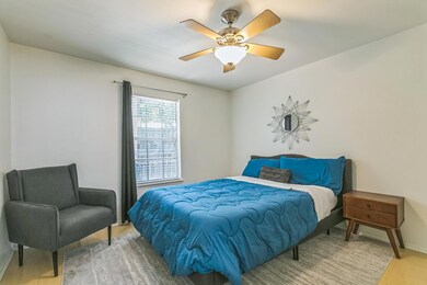 Bedroom with wood finished floors, baseboards, an