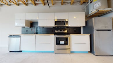 Kitchen featuring white cabinetry, appliances with