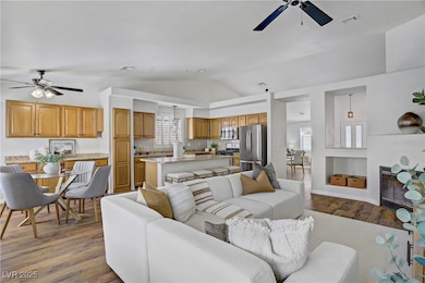 Living area featuring ceiling fan, vaulted ceiling