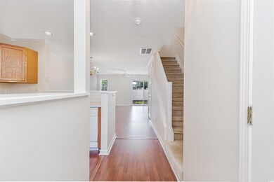 Hallway featuring a textured ceiling, a notable chandelier, crown molding, and dark wood-type flooring