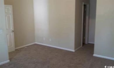 Carpeted spare room with baseboards