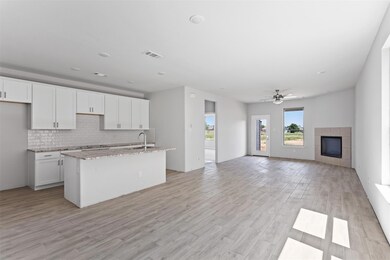 Kitchen with white cabinetry, a tiled fireplace, s