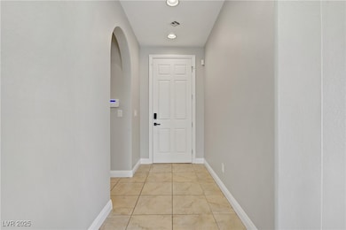 Entryway with tile patterned floors, arched walkways, and recessed lighting