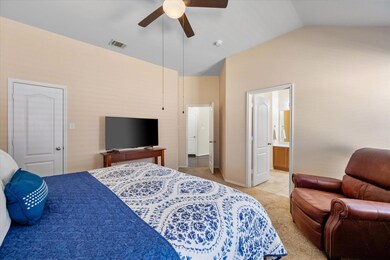 Bedroom featuring ensuite bathroom, visible vents,